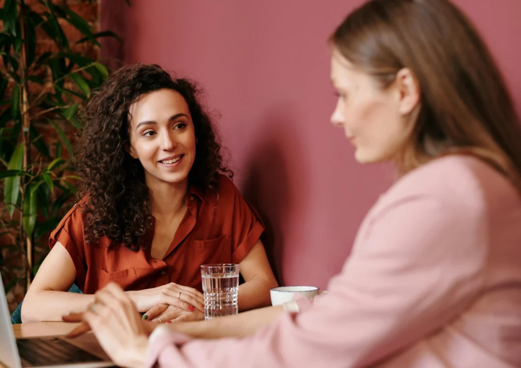 Twee vrouwen in gesprek tijdens persoonlijke begeleiding rond het aannemen van bijzonder talent