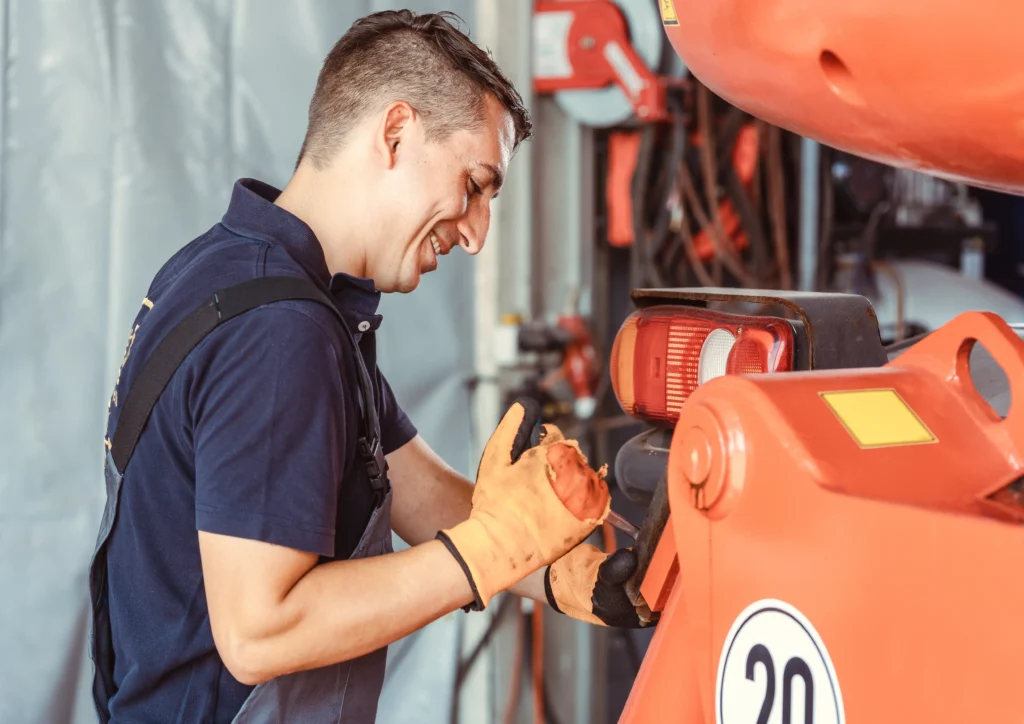 Medewerker met handschoenen aan het werk in een technische omgeving via het leerwerkbedrijf